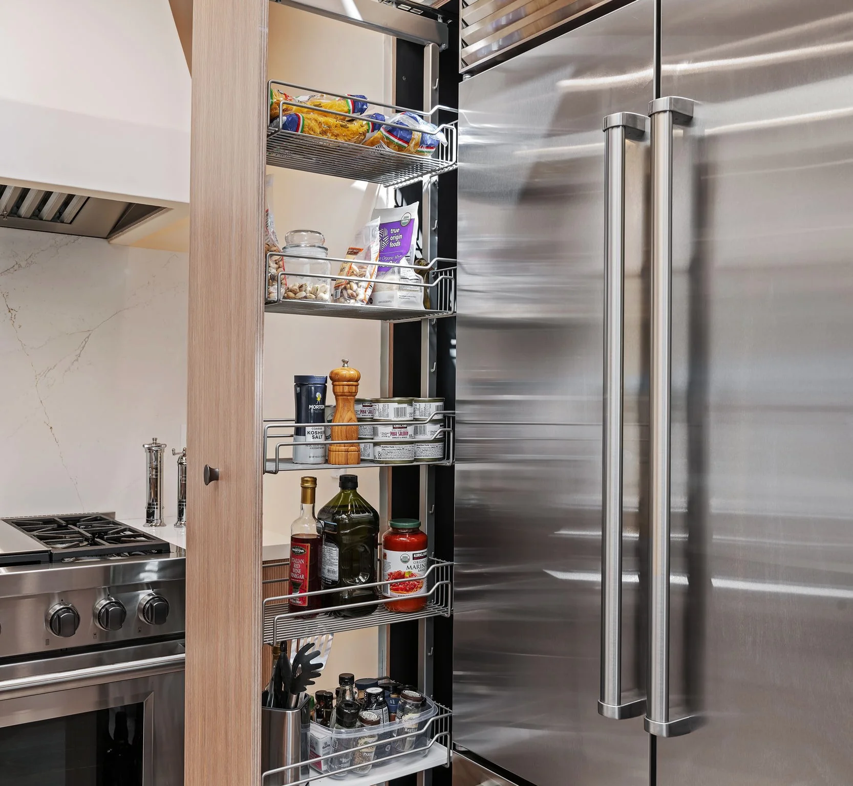 Tall pantry pullout beside the Sub-Zero column showing interior wire shelving